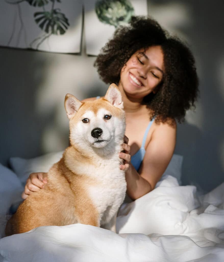 A smiling woman petting her dog