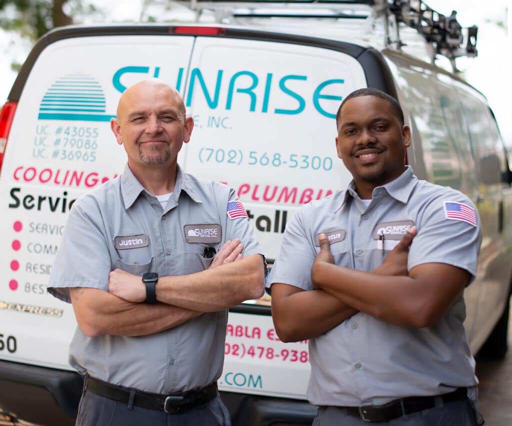 Two professional technician from Sunrise posing confidently in front of their service van.