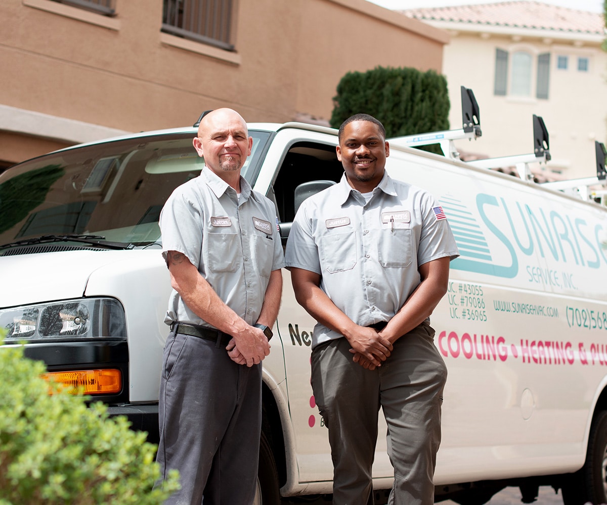 Two technicians from Sunrise Service, Inc. standing in front of their service van