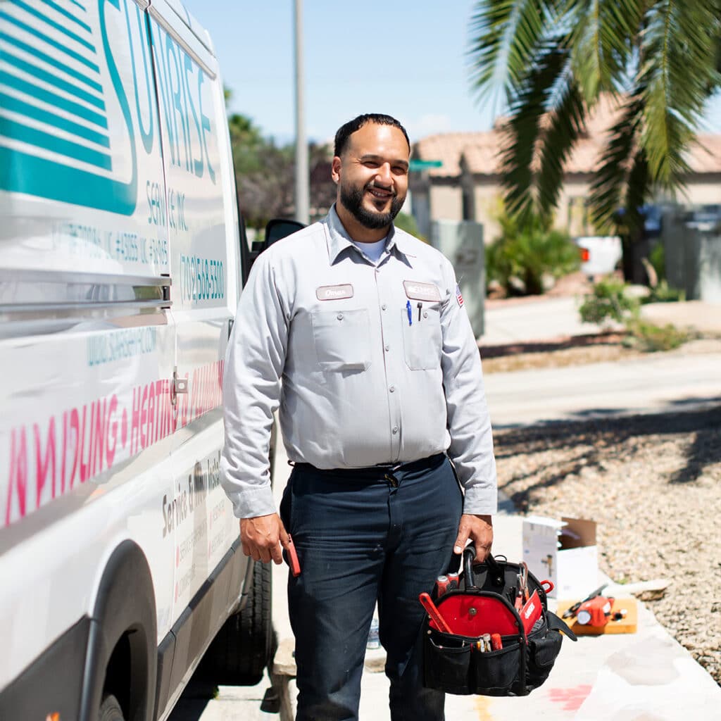 Sunrise technician smiling while standing by his service vehicle, showcasing his tools.