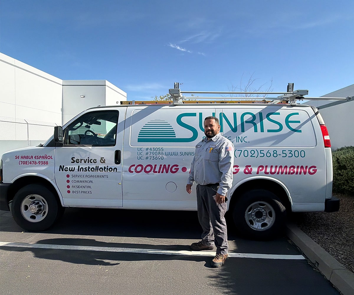 Sunrise Cooling, Heating & Plumbing technician standing beside a branded service van