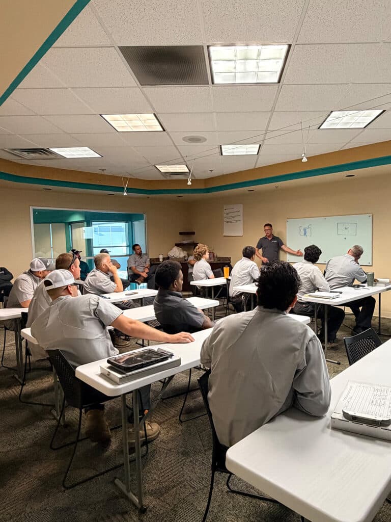 unrise HVAC team attending a training session led by an instructor at a whiteboard